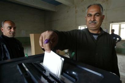 Iraqi man with inked finger drops his ballot